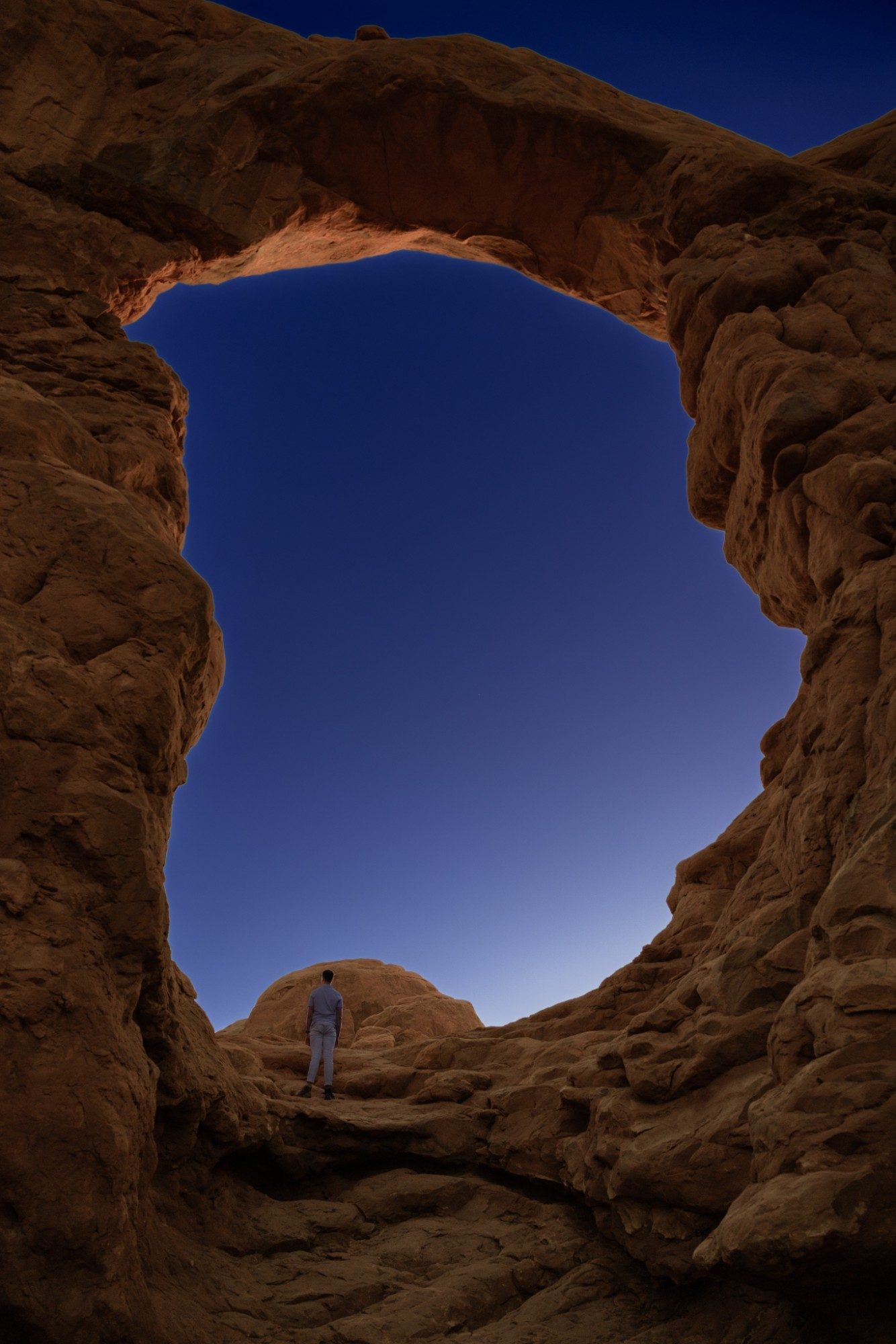 Griffin standing beneath a sandstone arch at dusk